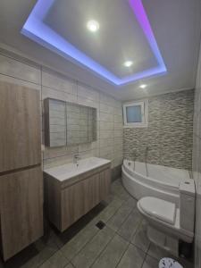 a bathroom with a tub and a toilet and a sink at Kalipso home in Mytilini