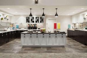 a large kitchen with white cabinets and a large island at Homewood Suites Rochester-Henrietta in Henrietta