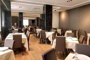 une salle à manger avec des tables et des chaises blanches dans l'établissement Hotel Park, à Castiglion Fiorentino