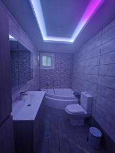 een badkamer met een bad, een toilet en een wastafel bij Kalipso home in Mytilini