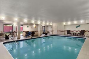 una piscina en una habitación de hotel con sillas y mesas en Hampton Inn Tracy, en Tracy
