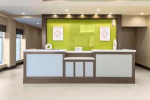 a lobby with a counter with a green wall at Hilton Garden Inn Ardmore in Ardmore