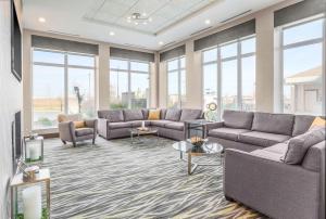 ein Wohnzimmer mit Sofas, Tischen und Fenstern in der Unterkunft Hilton Garden Inn Ardmore in Ardmore