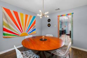 a dining room with a wooden table and a painting at That 70s House -Fun 6 Bedroom W Pool & Game Room in Round Rock