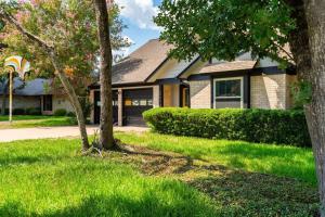 a house with green grass and trees in front of it at That 70s House -Fun 6 Bedroom W Pool & Game Room in Round Rock