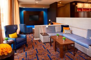 a lobby with couches and chairs and a television at Courtyard Chicago Deerfield in Deerfield