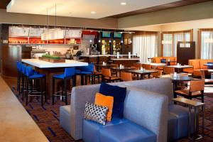 a restaurant with blue chairs and tables and a bar at Courtyard Chicago Deerfield in Deerfield