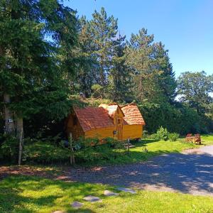 una cabaña de madera en medio de un patio con árboles en les Refuges du Chalet, en Sart-lez-Spa