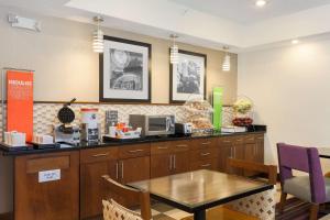 una cafetería con mesa y barra en Hampton Inn Decatur/Forsyth, en Forsyth