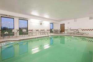 una piscina en un hotel con sillas y mesas en Hampton Inn Decatur/Forsyth, en Forsyth