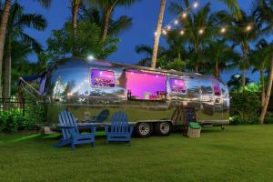una caravana verde estacionada en un patio con dos sillas azules en Hilton Garden Inn Key West / The Keys Collection, en Key West