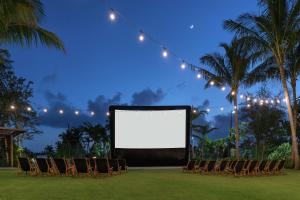 einen leeren Bildschirm auf einem Rasen mit Stühlen und Lichtern in der Unterkunft Hilton Garden Inn Key West / The Keys Collection in Key West