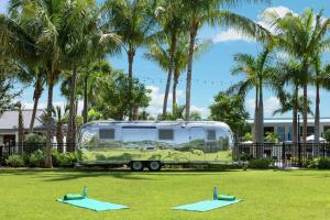 una caravana verde estacionada en un campo con árboles en Hilton Garden Inn Key West / The Keys Collection, en Key West