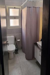 baño con aseo, ventana y lavamanos en Apartment Sierra Residence Close to The Airport en Sharm El Sheikh