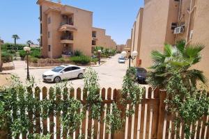 a wooden fence with cars parked in a parking lot at Apartment Sierra Residence Close to The Airport in Sharm El Sheikh