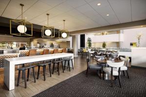 a restaurant with a bar and tables and chairs at Hilton Tucson East in Tucson