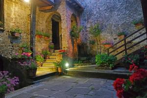 a courtyard with potted plants and stairs in a building at Antico Convento - Ospitalità Diffusa in Rocca Cilento