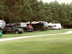 a group of tents and vehicles parked in a field at MacIver's Motel and Camp in Blind River