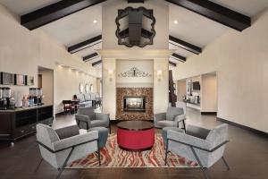 ein Wohnzimmer mit Stühlen und einem Kamin in der Unterkunft Hampton Inn & Suites Fort Wayne-North in Fort Wayne
