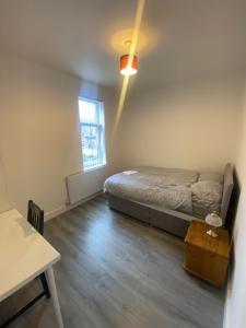 Un dormitorio con una cama y una mesa. en Luxury Fully Furnished Bedroom en Leicester
