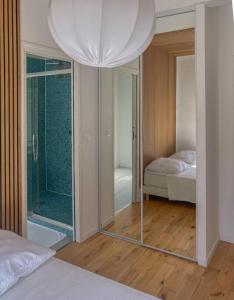 a bedroom with a mirror and a bed and a bedroom with a shower at Superbe Appartement au bord de la Garonne Toulouse in Toulouse