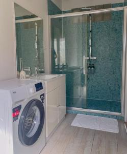 a bathroom with a washing machine and a shower at Superbe Appartement au bord de la Garonne Toulouse in Toulouse