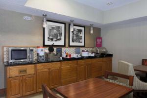 a kitchen with a microwave and a table in it at Hampton Inn St. Louis/Fairview Heights in Fairview Heights