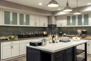 a kitchen with white cabinets and a white counter top at Homewood Suites by Hilton Erie in Erie