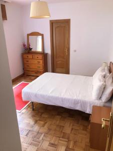 a bedroom with a bed and a dresser and a mirror at Apartamento Padrón Centro P5 by UR in Padrón