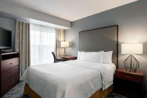 Homewood Suites by Hilton Erie في ايري: غرفة فندقية بسرير كبير ونافذة