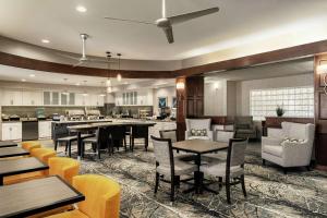 a restaurant with tables and chairs and a kitchen at Homewood Suites by Hilton Erie in Erie