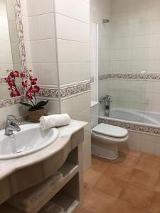 a bathroom with a sink and a toilet and a tub at Apartamento Padrón Centro P5 by UR in Padrón