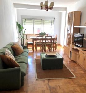 a living room with a green couch and a table at Apartamento Padrón Centro P5 by UR in Padrón