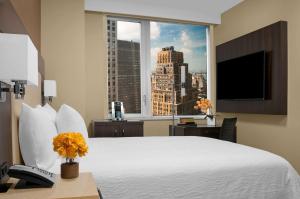 ニューヨークにあるHilton Garden Inn New York - Times Square Centralの白い大型ベッド1台と窓が備わるホテルルームです。