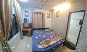 a small bedroom with a bed and a mirror at UDUPI HOMESTAY- White House 6 Br in Udupi