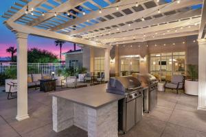 an outdoor kitchen with a pergola and a grill at Homewood Suites by Hilton Corpus Christi in Corpus Christi