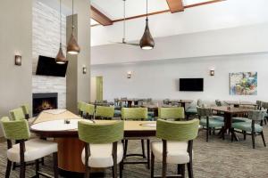 a dining room with tables and chairs and a fireplace at Homewood Suites by Hilton Dallas-Arlington in Arlington