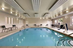 a large swimming pool with chairs and tables at Homewood Suites by Hilton Dallas-Arlington in Arlington