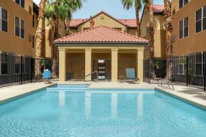 a swimming pool in front of a building with palm trees at Homewood Suites by Hilton Phoenix-Chandler in Chandler