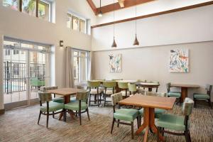 a dining room with tables and chairs and windows at Homewood Suites by Hilton Phoenix-Chandler in Chandler