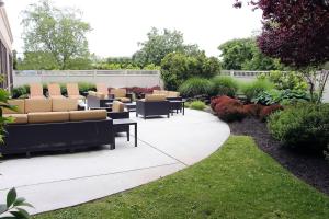 un patio avec des canapés et des tables dans un jardin dans l'établissement Courtyard by Marriott Lyndhurst/Meadowlands, à Lyndhurst