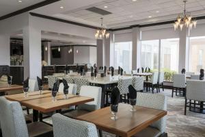 a dining room with tables and chairs and windows at Hilton Garden Inn Norman in Norman