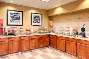 a kitchen with wooden cabinets and a counter top at Hampton Inn & Suites Palmdale in Palmdale
