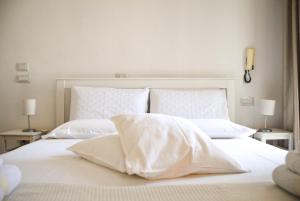 a white bed with white sheets and pillows at The Cathedral House in Bari