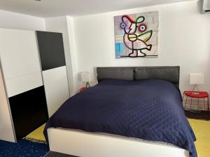 a bedroom with a bed with a blue comforter at Glads Apartment in Feldkirch