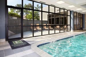 einen Pool in einem Haus mit einem großen Fenster in der Unterkunft Embassy Suites by Hilton Atlanta Galleria in Atlanta