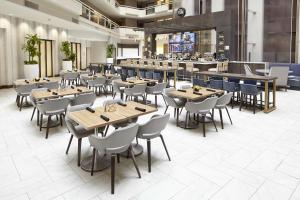 アトランタにあるEmbassy Suites by Hilton Atlanta Galleriaのテーブルと椅子のあるレストラン、バー