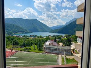 a tennis court with a view of a lake at Bright Modern Holiday Home With Postcard Lake View in Pluzine