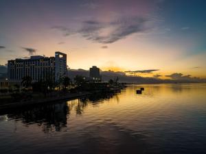 um pôr-do-sol sobre uma massa de água com edifícios em ROK Hotel Kingston Tapestry Collection By Hilton em Kingston