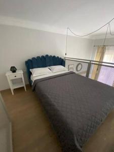 een slaapkamer met een bed en een blauwe stoel bij Apartament in stil unic langa Primaria Arad in Arad